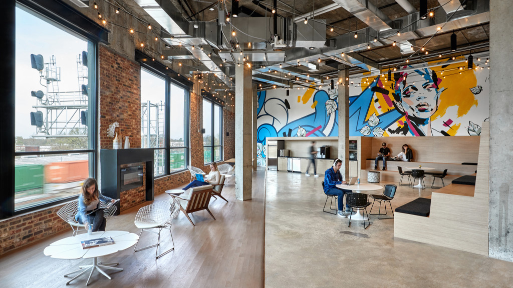 A room with tables and chairs and people in it.